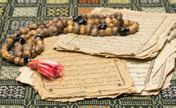 Muslim prayer beads with ancient pages from the Koran. Islamic and Muslim concepts. Ancient old sheets of paper from the Arabic book