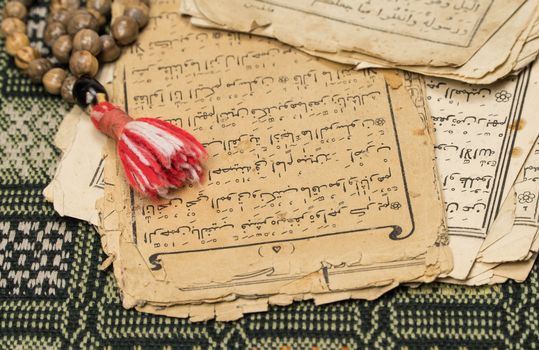 Muslim prayer beads with ancient pages from the Koran. Islamic and Muslim concepts. Ancient old sheets of paper from the Arabic book