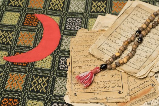 Muslim prayer beads with ancient pages from the Koran. Islamic and Muslim concepts. Ancient old sheets of paper from the Arabic book