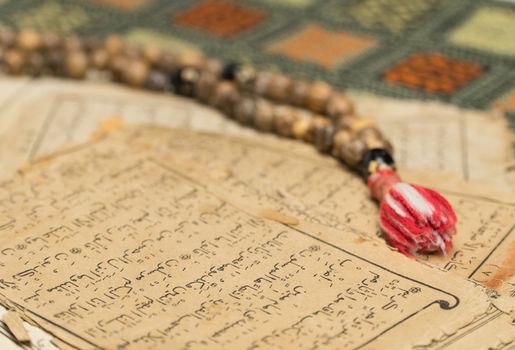 Muslim prayer beads with ancient pages from the Koran. Islamic and Muslim concepts. Ancient old sheets of paper from the Arabic book