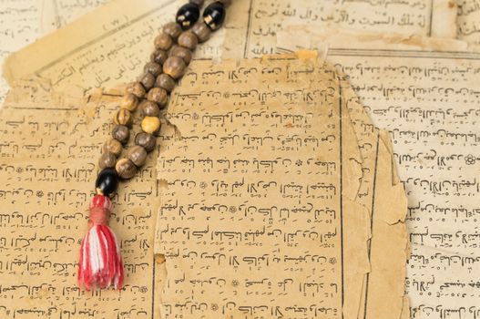 Muslim prayer beads with ancient pages from the Koran. Islamic and Muslim concepts. Ancient old sheets of paper from the Arabic book