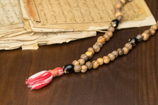 Muslim prayer beads with ancient pages from the Koran. Islamic and Muslim concepts. Ancient old sheets of paper from the Arabic book