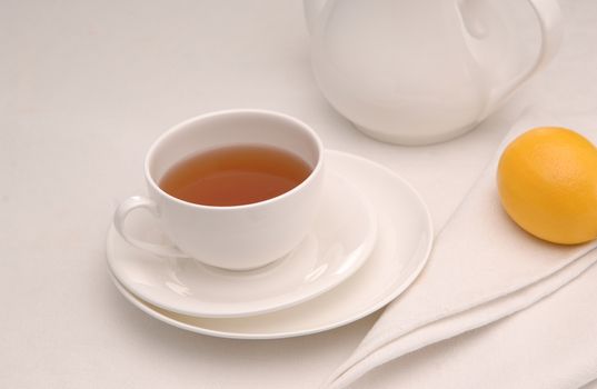 on a napkin cup of tea with lemon in a saucer and teapot