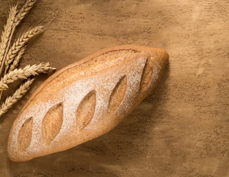 a loaf of bread and a Golden spike on the plastered surface, top view