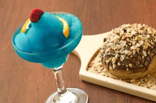 bread garnished with nuts on a wooden plate and a glass of ice-cream with raspberry and lemon