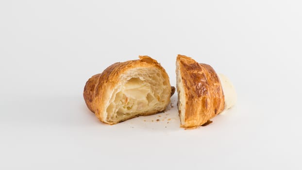 sliced croissant with cream filling on a white background