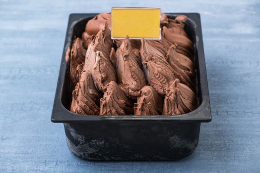 appetizing ice cream in a plastic container with a price tag on a decorative blue background