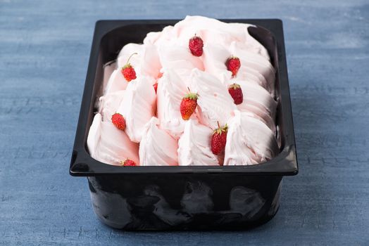 appetizing ice cream in a plastic container on a decorative blue background