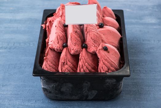 appetizing ice cream in a plastic container with a price tag on a decorative blue background