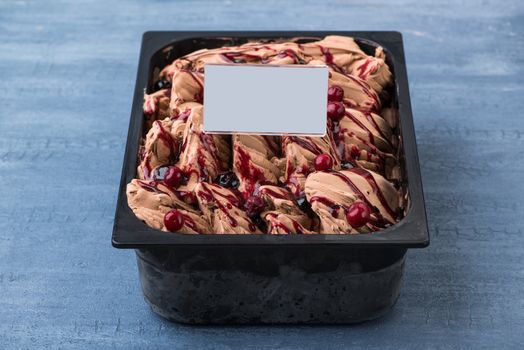 appetizing ice cream in a plastic container with a price tag on a decorative blue background