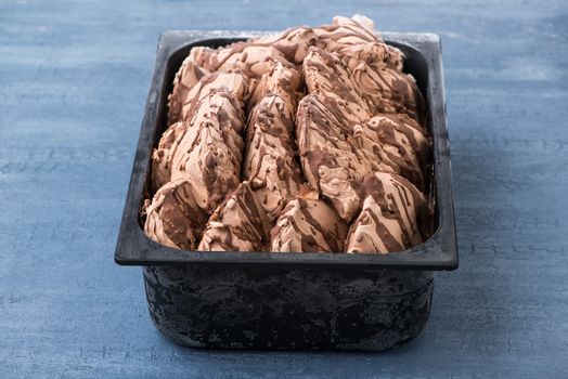 appetizing ice cream in a plastic container on a decorative blue background