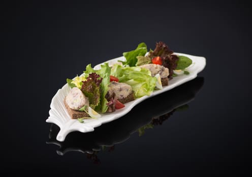 meat salad with eggs on a black background, isolated