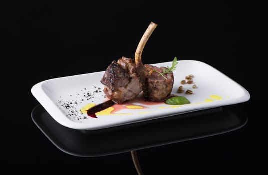 roasted meat in a plate on a black background, isolated