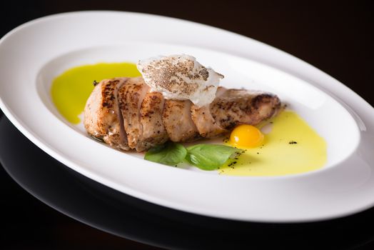 dish of meat with egg in a plate, on a black background, isolated