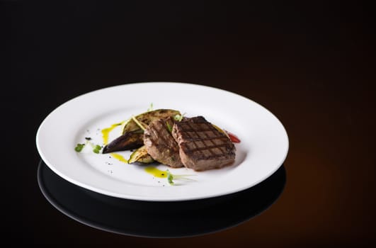 dish of fried meat in a plate on a black background