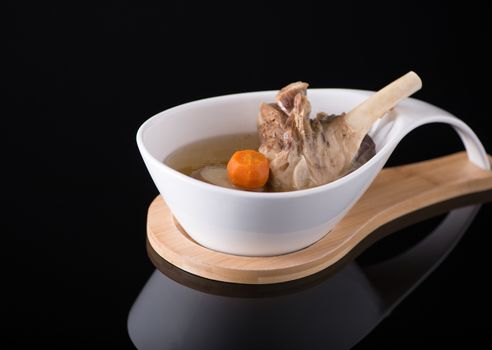 meat soup in a white bowl on a black background, isolated