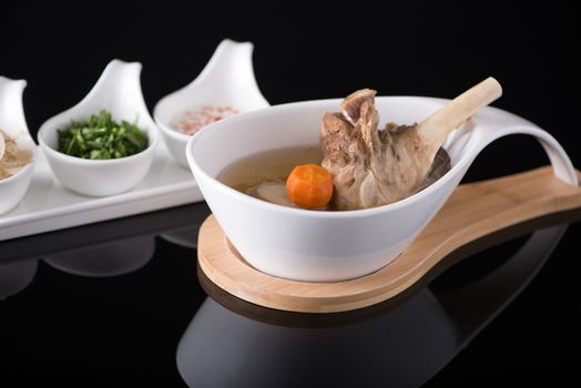 meat soup in a white bowl on a black background, isolated