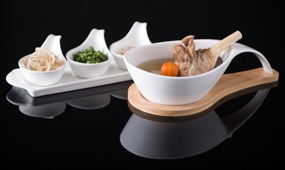 meat soup in a white bowl on a black background, isolated