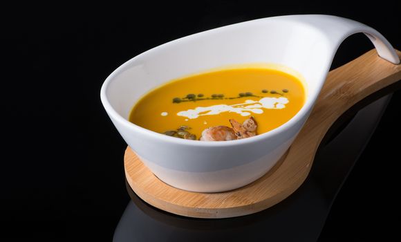 shrimp soup in a white cup on a black background, isolated