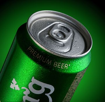 Almaty, Kazakhstan - October 11, 2019: can of beer Carlsberg with drops of water in a green background with illumination. Advertising a brand of beer