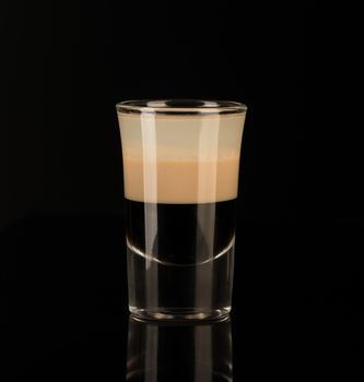 mixed alcoholic liquor in a shot glass isolated on a black background