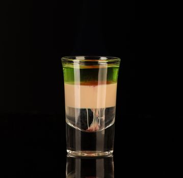 mixed alcoholic liquor in a shot glass isolated on a black background