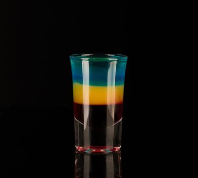 mixed alcoholic liquor in a shot glass isolated on a black background