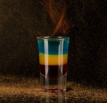 flaming cocktail with cinnamon in a shot glass on a black background, isolated