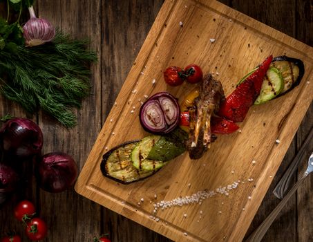 pieces of fried meat and vegetables on a cutting board, top view