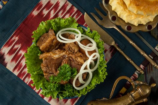 fried meat and onion rings on an oriental tablecloth