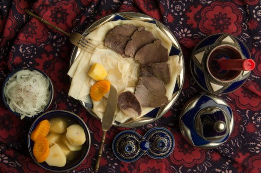 oriental dish of boiled meat and dough on a tablecloth