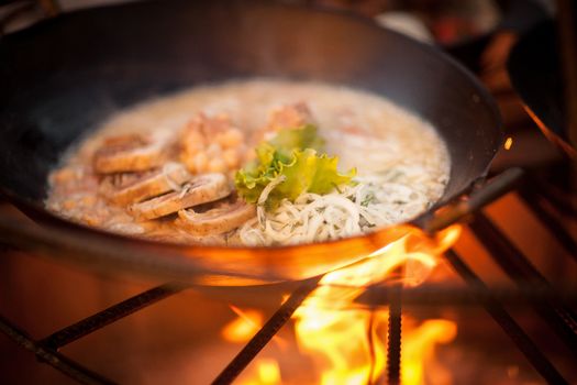 cook a meat dish with peas at the stake with spruce branches