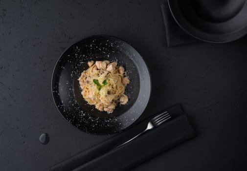 a dish of chicken on the black wooden surface, top view