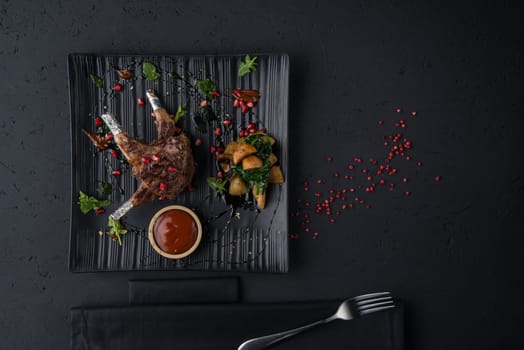 a dish of grilled meat on the black wooden surface, top view