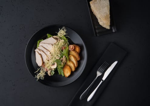 a dish of chicken on the black wooden surface, top view