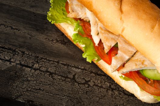 cheeseburger on an old wooden surface of dark color. hamburger with chicken meat on an old wooden surface of dark color