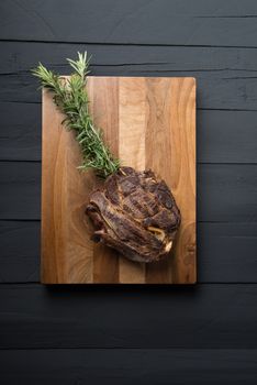roasted meat on a black wooden background