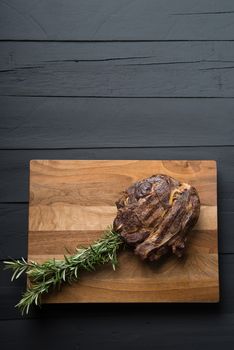 roasted meat on a cutting board on a black wooden background