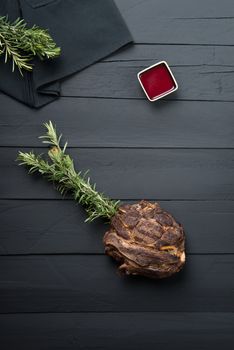 fried meat with greens, sauce and gravy on a black wooden background