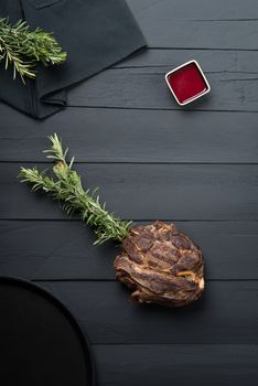 fried meat with greens, sauce and gravy on a black wooden background