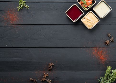 greens, sauce and gravy on a black wooden background