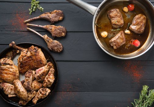 roasted meat in a pan on a black wooden background