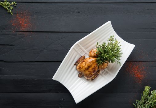 fried chicken in a white plate on a black wooden background