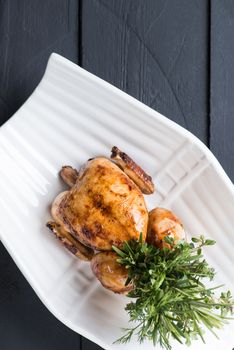 fried chicken in a white plate on a black wooden background