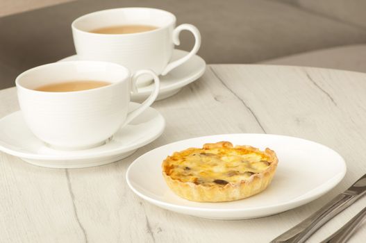 cake and two cups of coffee on a table with cutlery