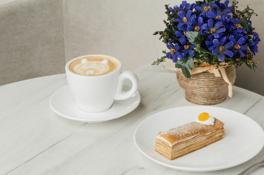 cake and cup of coffee on a table with flowers