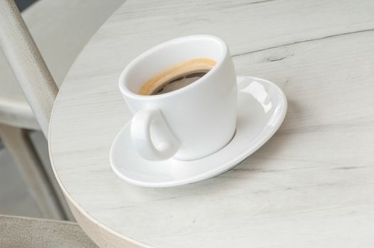 Coffee cup and saucer on a round table