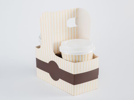 paper cups with coffee in a takeaway box on a white background