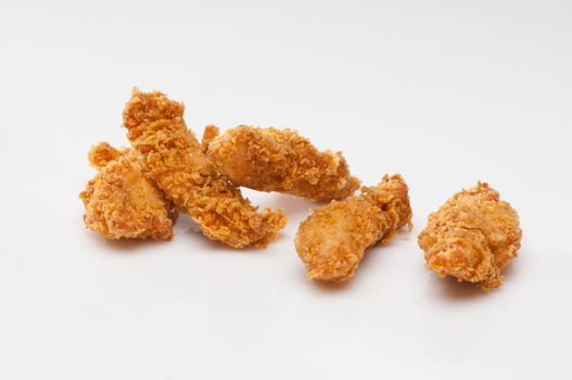 chicken pieces in bread crumbs close up on a white background