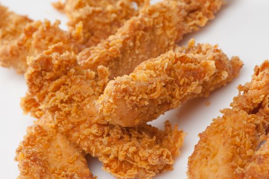 chicken pieces in bread crumbs close up on a white background